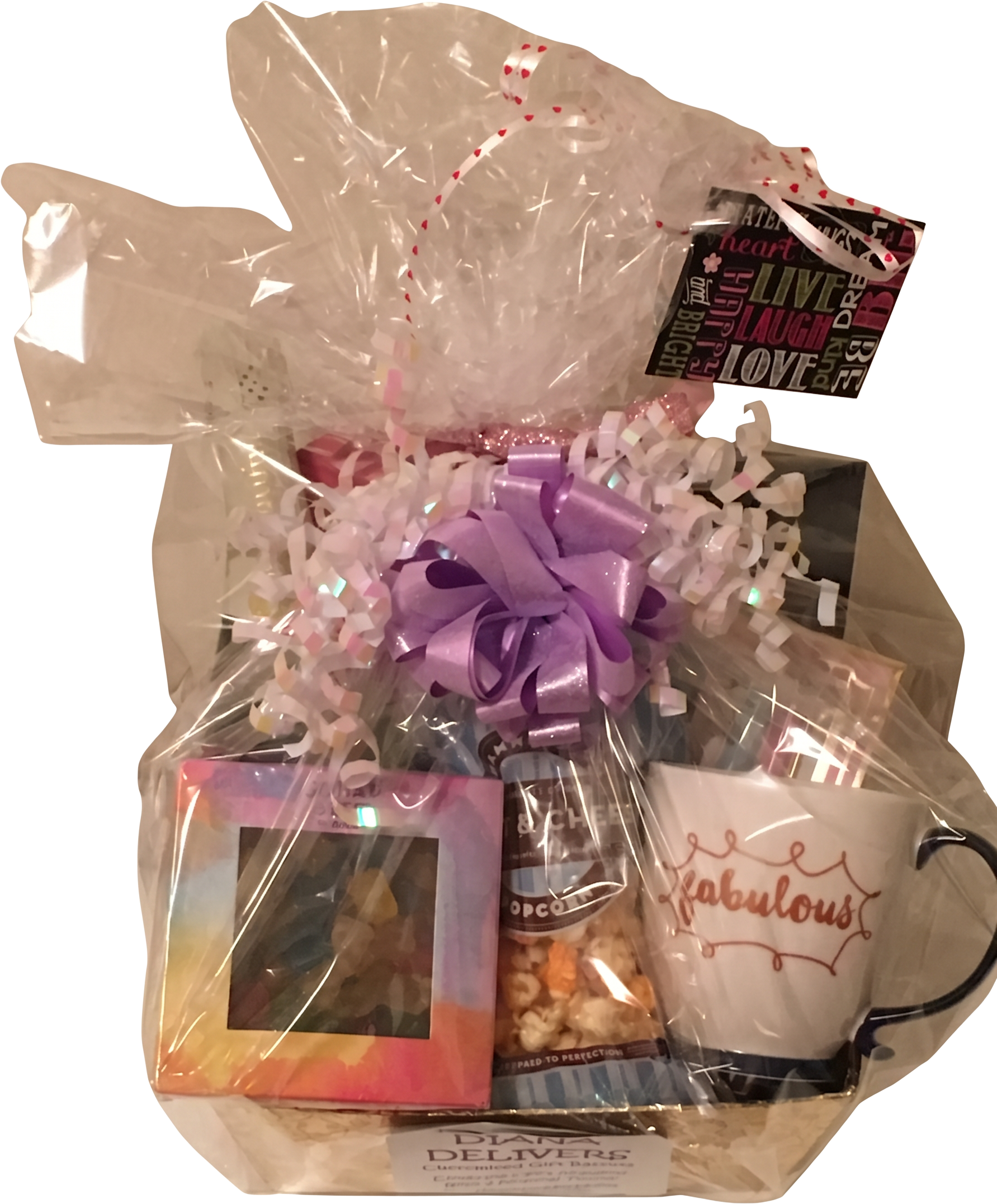 Wrapped gift basket with a purple bow, popcorn, gummies, and a fabulous mug
