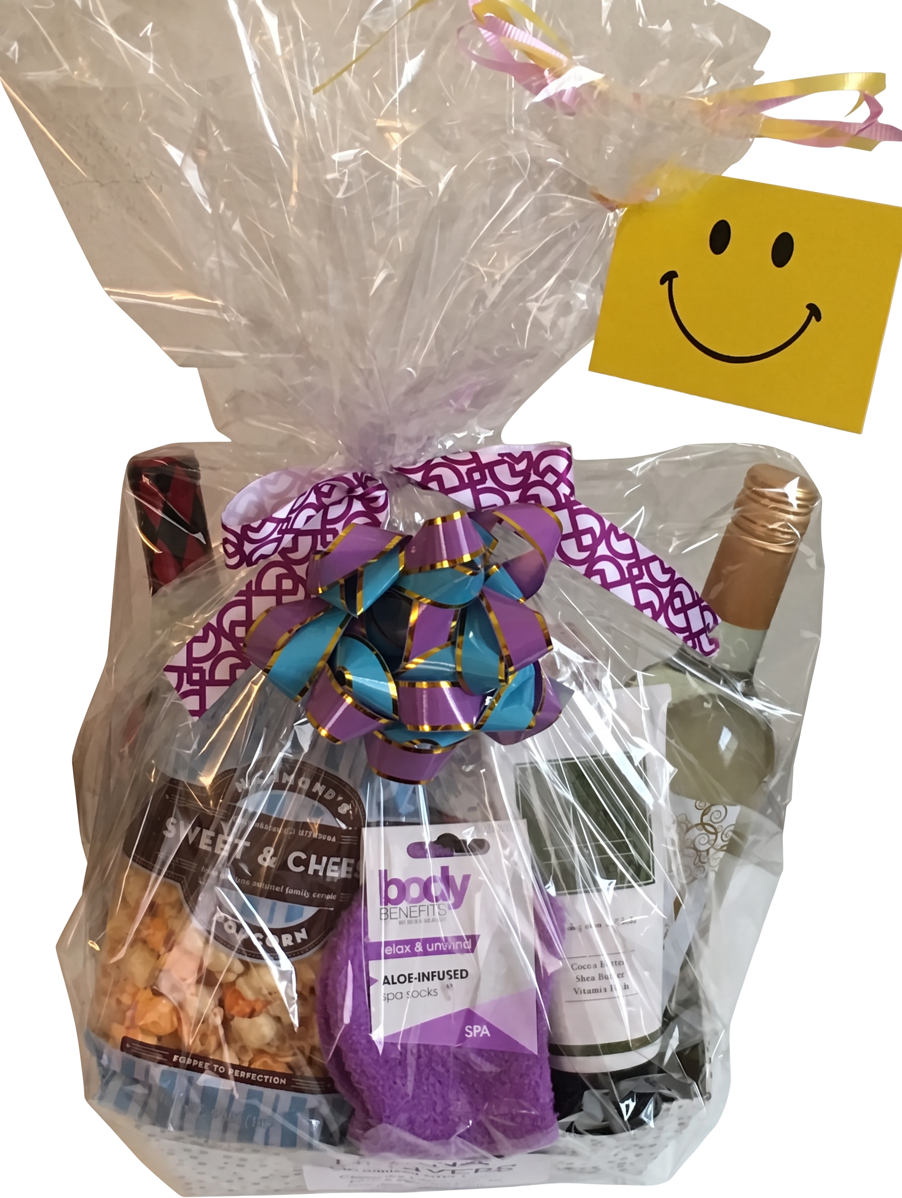 Gift basket with wine, popcorn, spa socks, and a smiley face card